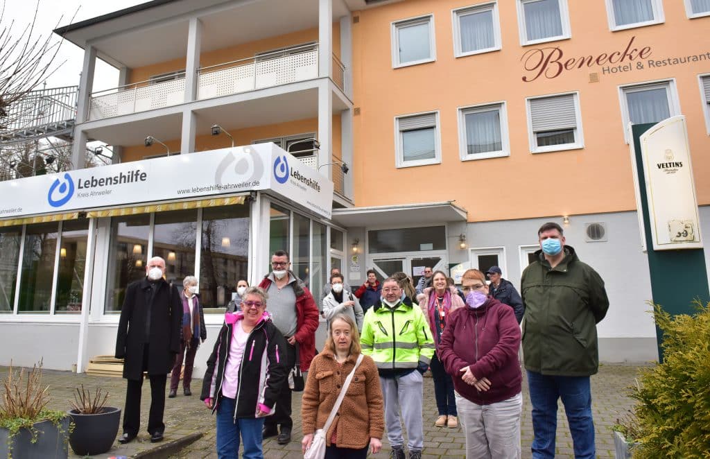 Eine Gruppe von Maskierten steht vor dem Benecke Hotel und Lebenshilfe-Gebäude.
