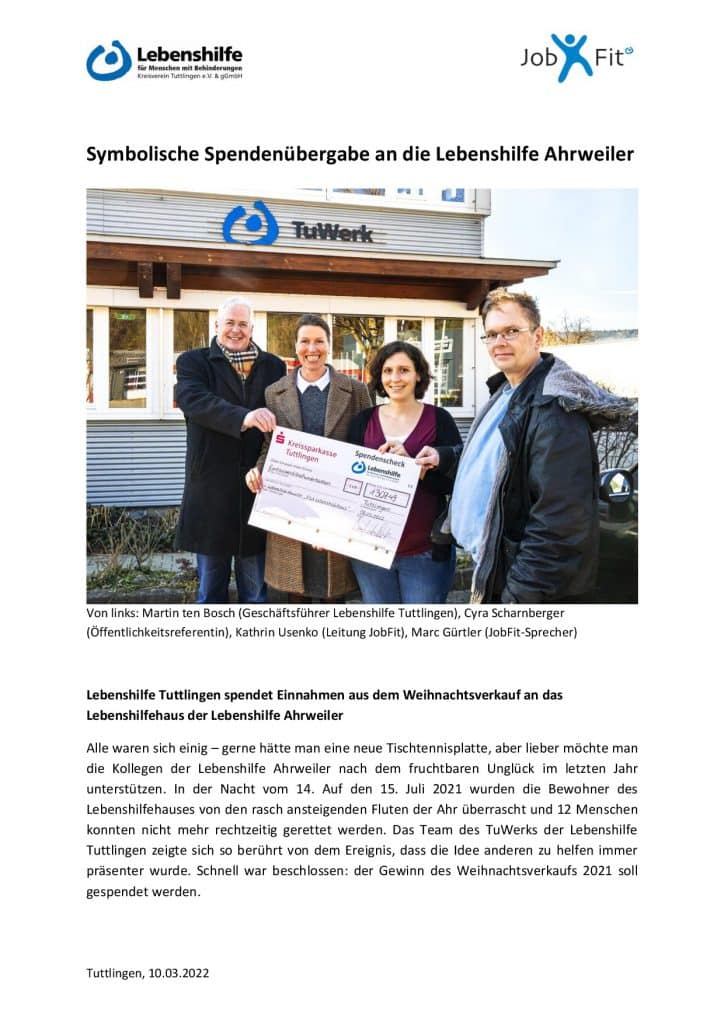 Drei Personen halten einen großen Spendenscheck vor einem Gebäude mit TuWerk-Schriftzug.