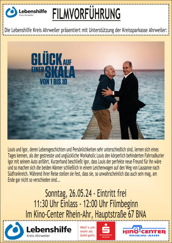 Zwei Männer in Anzügen umarmen sich und lächeln, während sie auf einer Brücke über dem Wasser stehen.