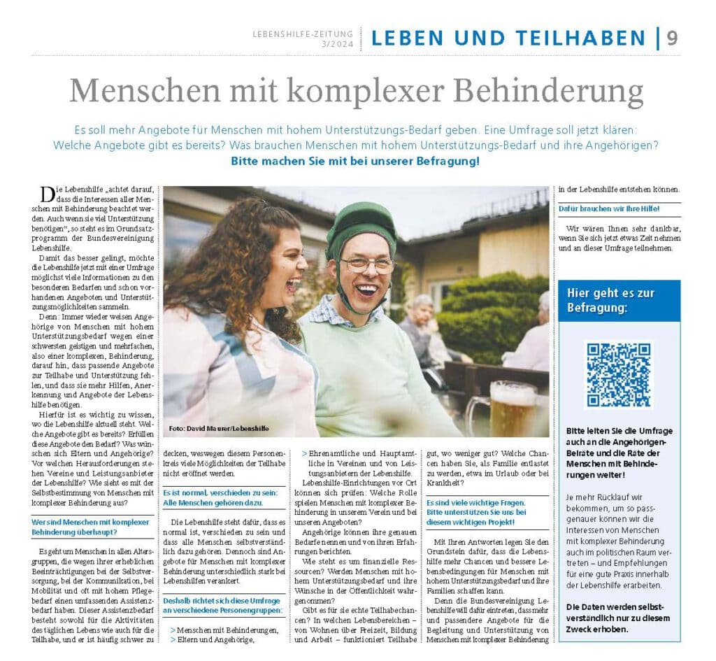 Drei Personen sitzen draußen an einem Tisch, lächeln und trinken, eine Frau lacht dabei.